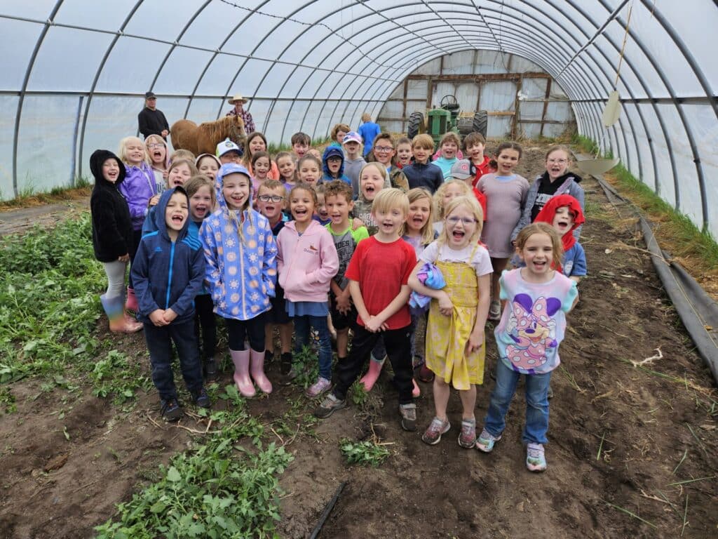 A Group Of Students Engaged In A Greenhouse