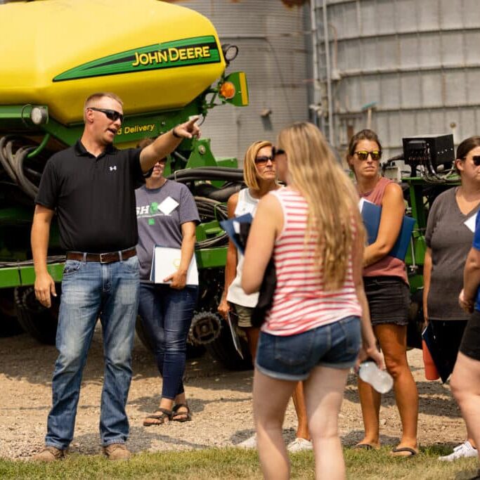 K 12 Educators Gather In Front Of A Tractor