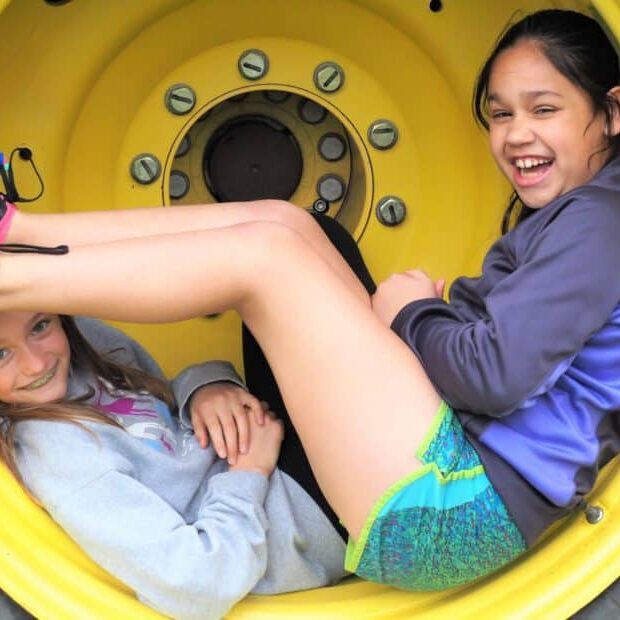 Two Students Engaging Inside A Yellow Tire